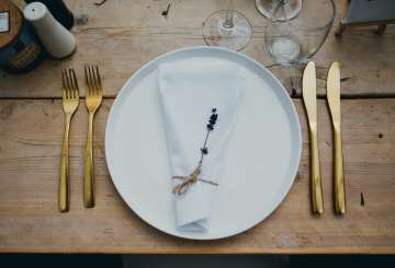 Bord met gouden bestek en stoffen serviette met lavendeltakje